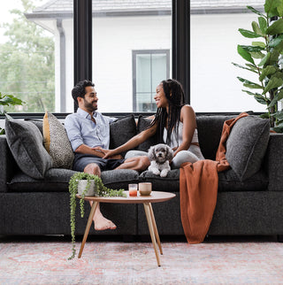 couple with dog relaxing on charcoal kova sofa